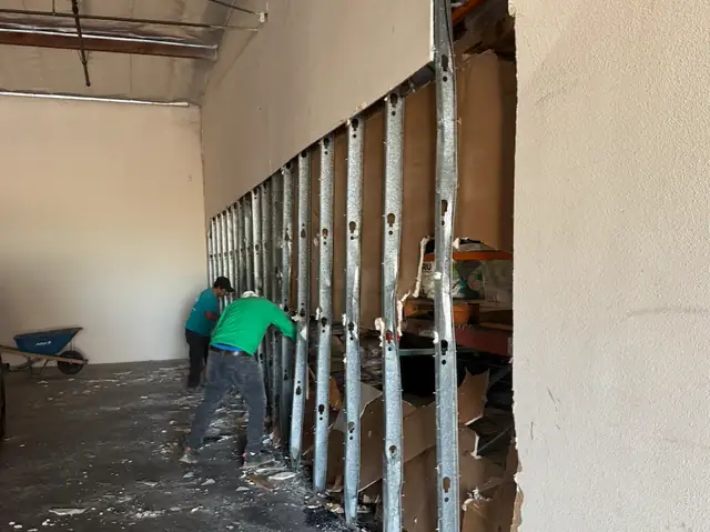 Crew taking down a wall in a commercial space