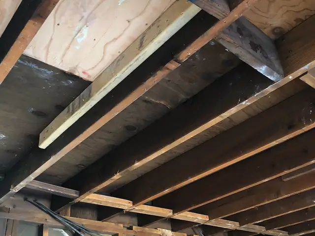 Soot-blackened framing and exposed joists after a fire