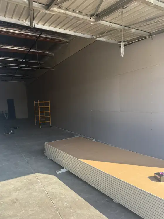 Drywall hung and stacked on the floor in a commercial space